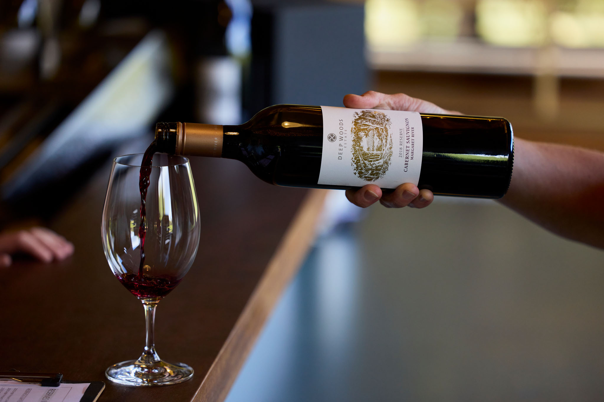 A bottle of wine being poured into a wine glass 